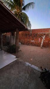 贝贝里比Casa Temporada Beberibe的一个带砖墙和棕榈树的庭院