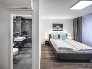 曼海姆Mood contemporary living的一间带大床的卧室和一间浴室