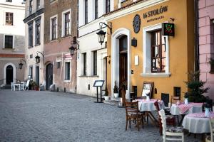 卢布林Apartamenty Kamienica Muzyków Old Town Lublin的大楼前一条带桌椅的空街道