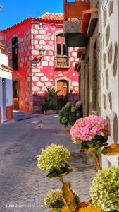 圣巴托洛梅Rural Suite Santiago de Tunte的前面有鲜花的红色建筑