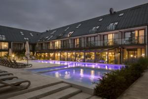 韦巴Hotel Saltic Resort & Spa Łeba的大楼前设有游泳池的酒店