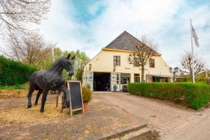 WesternielandDe Oude Smidse的站在标志旁的马雕像
