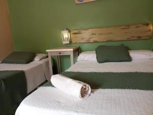 伊瓜苏港Ára apart的绿墙客房内的两张床