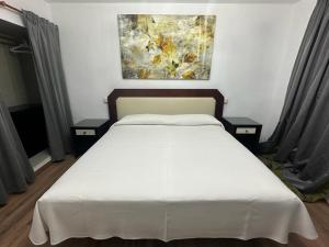 圣拉菲尔芬卡拉卡索纳高级客房酒店的一间卧室配有白色床和2个床头柜