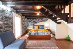 蓬他达维托亚Casa da Vizinha的石墙客房的卧室配有床