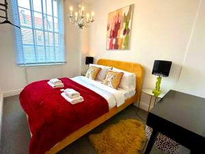 布里斯托Bristol City Stays - Cabot Circus的一间卧室配有一张带红色毯子的床