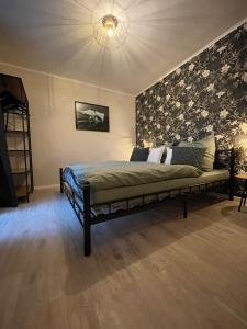 伊达尔-奥伯施泰因Ferienhaus Kleine Auszeit的一间卧室配有一张带花卉图案墙壁的床