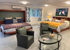 MiddlesexAracari Lodge & Jungalows的卧室配有一张床和一张桌子及椅子