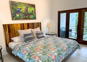MiddlesexAracari Lodge & Jungalows的一间卧室配有一张带五颜六色棉被的床