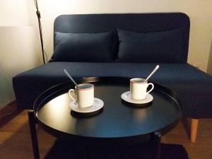 格勒诺布尔Le Paisible - Gare - Duplex - Garage privé - Netflix的沙发前桌子上放两个咖啡杯