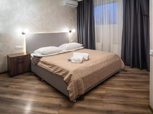文尼察Safari-Club的一间卧室配有一张床,上面有两条毛巾