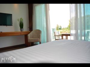 拉威海滩行动点减肥健身度假酒店的一间卧室配有一张床、一台电视和一张书桌
