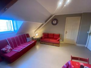 Pugny-ChatenodLocation montagne le Revard的客厅配有紫色和红色的沙发以及时钟