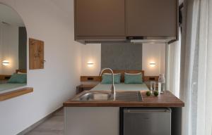 萨尔蒂Vrahakia beach的一个带水槽的厨房和一张位于客房内的床
