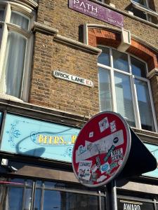 伦敦Liverpool Street Green Bedroom的砖楼前的街道标志