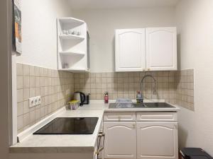 伍珀塔尔Accomodation in wuppertal的小厨房配有白色橱柜和水槽