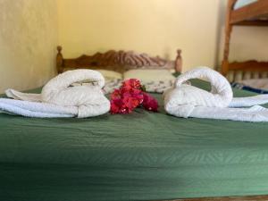 Santo DomingoPlaya Casa Nohelia的床上的两条毛巾,带鲜花
