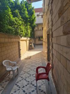 开罗Happy pyramids inn Hotel的两把椅子坐在小巷的人行道上
