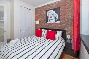 纽约Modern 3BR Apartment in NYC的一间卧室设有一张带砖墙的大床