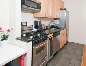 纽约Modern 3BR Apartment in NYC的厨房配有不锈钢炉灶 顶部烤箱