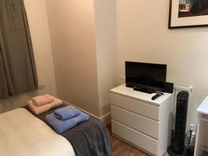 伦敦Notting Hill Next Door Bedroom in the share flat的一间小卧室,配有一张床和梳妆台上的电视