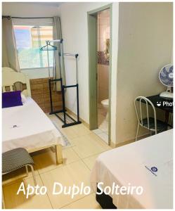 戈亚斯州上帕莱索Pousada Estrela Veadeiros的客房设有两张床和一间带卫生间的浴室。