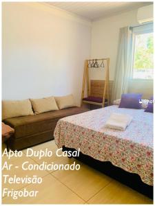戈亚斯州上帕莱索Pousada Estrela Veadeiros的一间卧室配有一张床和一张沙发