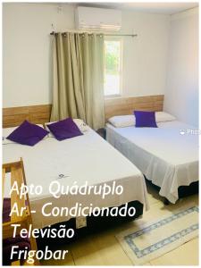 戈亚斯州上帕莱索Pousada Estrela Veadeiros的带窗户的客房内的两张床