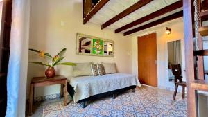 帕拉蒂Canto do Jão的一间卧室配有一张床和一张植物桌子