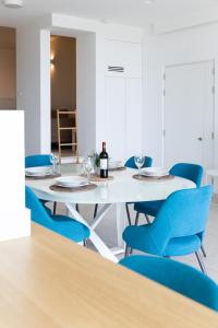 圣朱利安斯Modern apartment in the center of St Julians的一间配备有白色桌子和蓝色椅子的用餐室