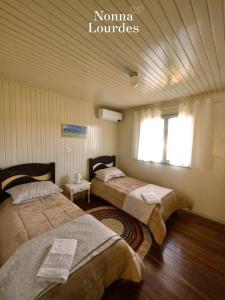 本图贡萨尔维斯Recanto Nonna Lourdes - Vale dos Vinhedos的一间卧室设有两张床和窗户。