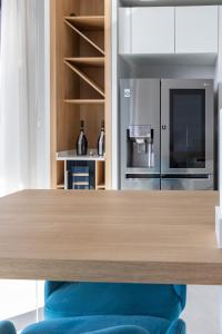 圣朱利安斯Modern apartment in the center of St Julians的厨房配有木桌和冰箱。