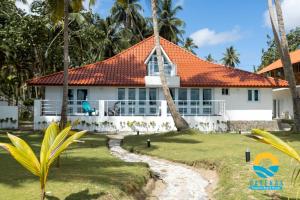 Beachfront Vacation Villa的白色房子,有橙色屋顶