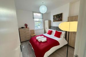 伦敦Parkside Stay North London - Victoria Line的一间卧室配有一张带红色枕头的大床