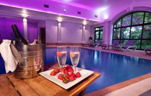 切斯特Crabwall Manor & Spa - BW Signature Collection的一个带两杯香槟和草莓的桌子游泳池