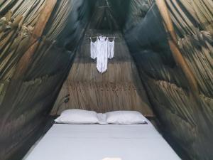巴卡拉尔Hakuna Matata Glamping的帐篷内的一张床位,配有两个枕头