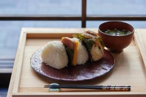 东京SAKE Bar Hotel Asakusa的盘子上盘的寿司和一杯汤