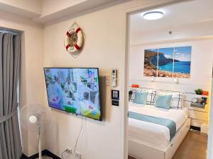 马尼拉CELANDINE Residence by DMCI的一间卧室配有一张床和一台平面电视