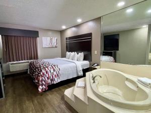 里奇兰Red Roof Inn & Suites Richland的酒店客房配有一张床和浴缸。