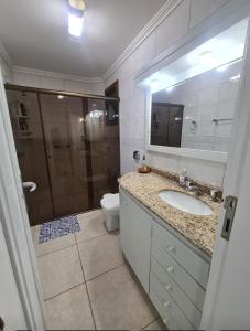 卡庞达卡诺阿Apartamento Beira mar Capão da Canoa的带淋浴、盥洗盆和卫生间的浴室