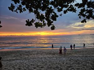高兰Lanta Riviera Resort - SHA Extra Plus的一群人,在日落时站在海滩上