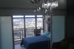 马尼拉Penthouse at Poblacion - 200Mbs net - Awesome view的一间卧室设有蓝色的床和大窗户