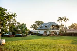 波萨达斯" Casa quinta "San Bernardo" Con Pileta y amplio jardín的院子里的白色房子,有灰色的屋顶