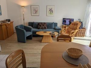 奥斯赛拜-屈隆斯博恩Ferienanlage-Reriker-Strasse-EG-rechts-119的客厅配有蓝色的沙发和桌子