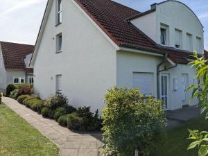 奥斯赛拜-屈隆斯博恩Ferienanlage-Reriker-Strasse-EG-rechts-119的白色房子,有红色屋顶
