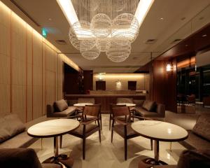 大阪Candeo Hotels Osaka Shinsaibashi的大堂设有桌椅和酒吧。