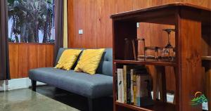 QuesadaCabaña Colibrí的书架旁的蓝色沙发,带黄色枕头