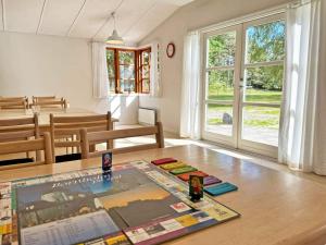 维斯特索马肯Holiday home Aakirkeby VI的客厅配有一张桌子和报纸,位于地板上