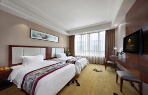 宝安深圳市福永鸿利来酒店的酒店客房设有两张床和电视。