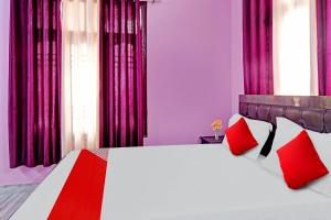 巴特那Flagship Hotel The Pinkcity的一间卧室配有一张带红色枕头的大床